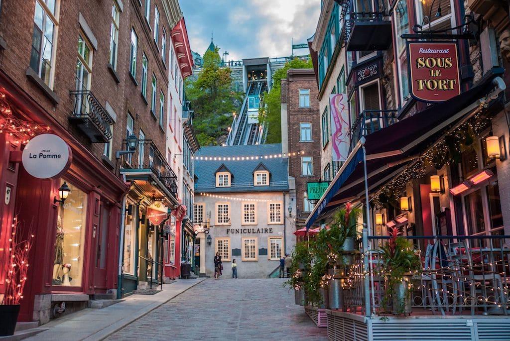 Audrey et Christophe attablés dans une rue du Vieux-Québec, sous les toits de cuivre